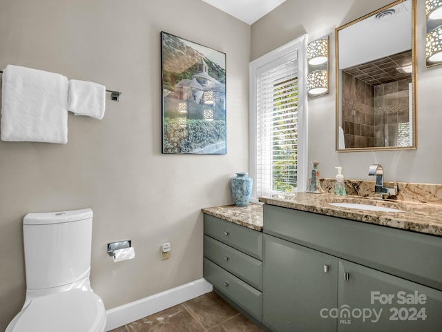 bathroom featuring tile patterned floors, vanity, toilet, and tiled shower