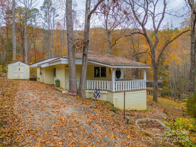 view of front of home featuring covered porch and a storage shed