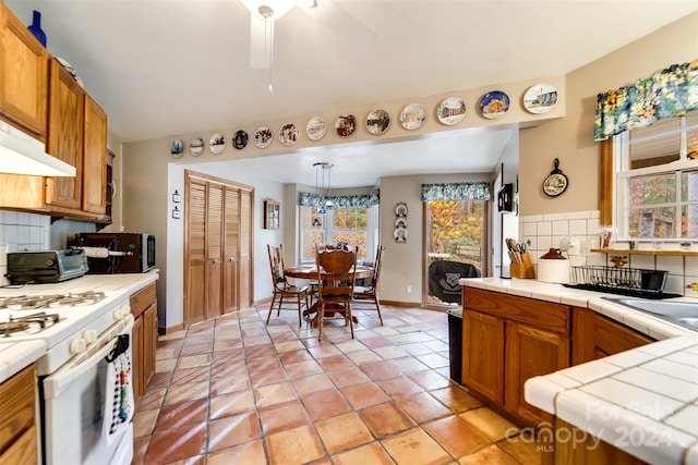 kitchen featuring a wealth of natural light, backsplash, and tile counters