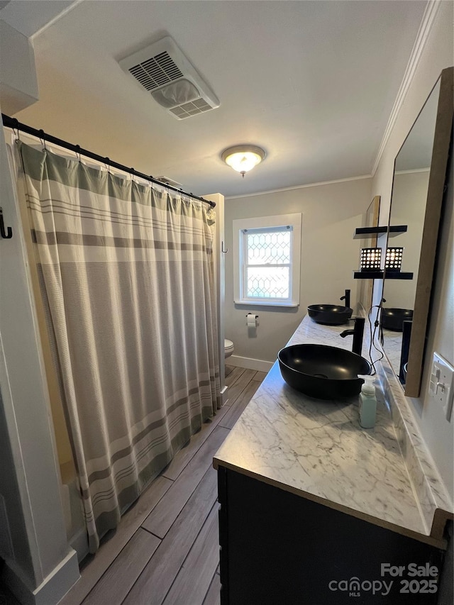 full bathroom with double vanity, visible vents, toilet, wood finished floors, and a sink