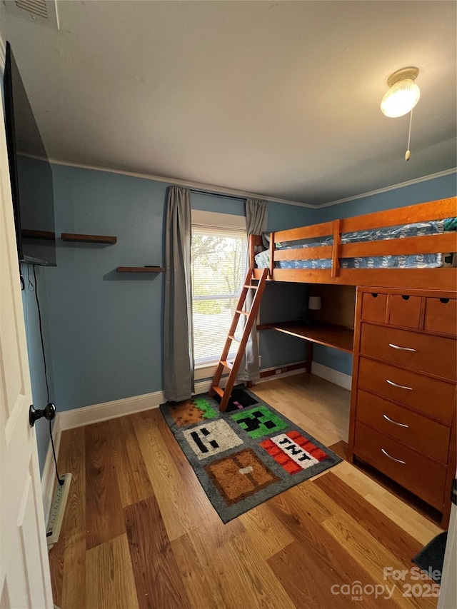 bedroom featuring light wood-type flooring, visible vents, and baseboards