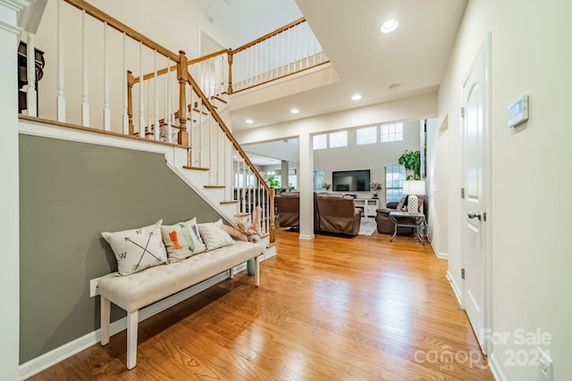 living room with light hardwood / wood-style floors and a high ceiling