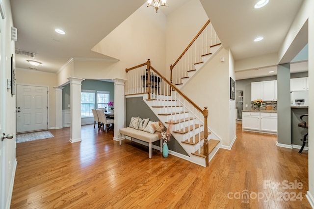 stairway with hardwood / wood-style floors and an inviting chandelier