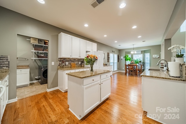 kitchen featuring white cabinetry, a kitchen island with sink, white refrigerator, light hardwood / wood-style floors, and decorative backsplash