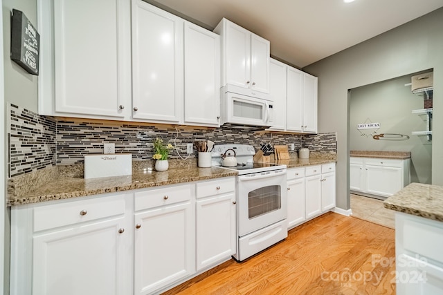 kitchen with white cabinetry, stone countertops, light hardwood / wood-style floors, and white appliances