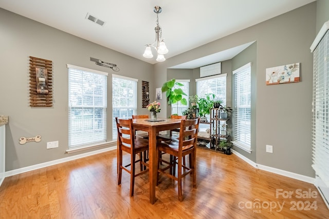 dining room featuring light wood-type flooring and an inviting chandelier