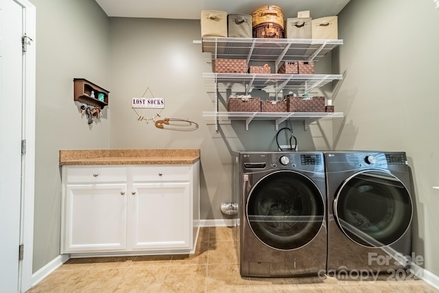 laundry area featuring independent washer and dryer, cabinets, and light tile patterned floors