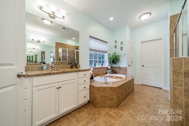 bathroom featuring tile patterned flooring, vanity, and shower with separate bathtub