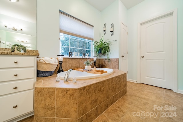 bathroom with vanity, a relaxing tiled tub, and tile patterned floors