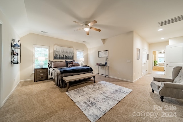 carpeted bedroom with ceiling fan, ensuite bathroom, and vaulted ceiling