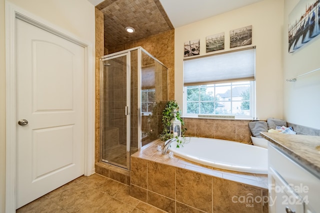 bathroom with tile patterned flooring, vanity, and shower with separate bathtub