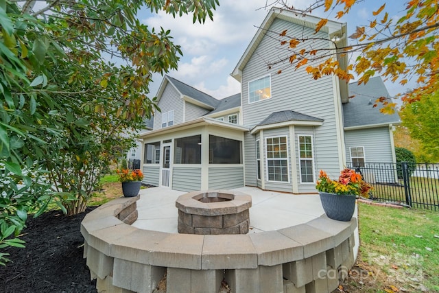 rear view of house featuring a patio, a fire pit, and a sunroom