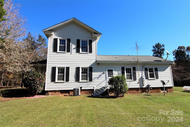 rear view of property with a yard and cooling unit