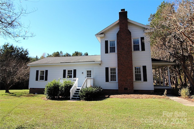 rear view of property featuring a yard