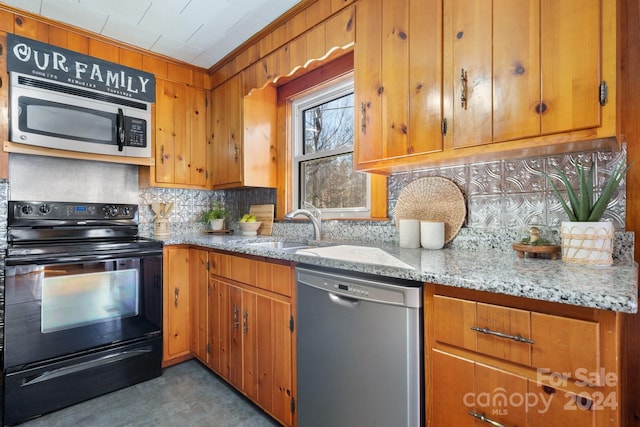 kitchen with ornamental molding, sink, appliances with stainless steel finishes, tasteful backsplash, and light stone counters