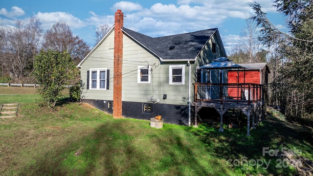 back of property with a gazebo, a lawn, and a wooden deck