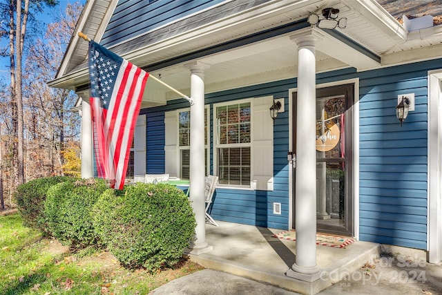 view of exterior entry featuring covered porch