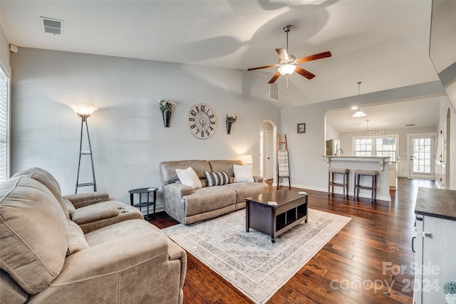 living room featuring dark hardwood / wood-style floors, ceiling fan, and vaulted ceiling