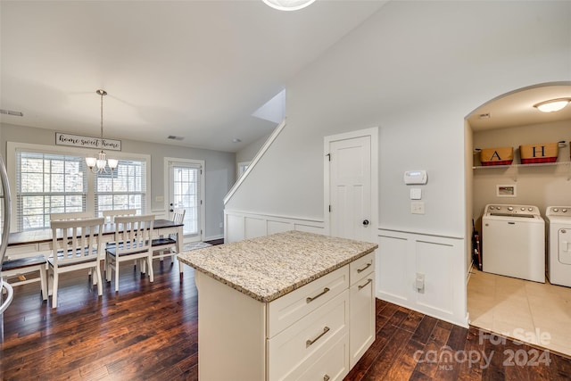 kitchen featuring pendant lighting, a center island, separate washer and dryer, and dark hardwood / wood-style floors