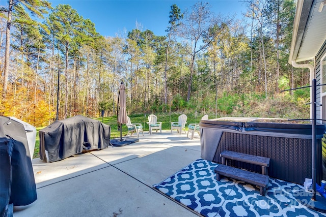 view of patio with area for grilling and a hot tub