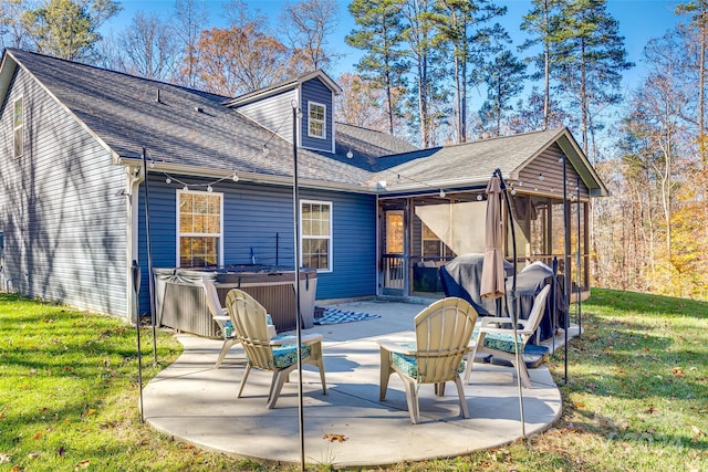 back of property featuring a lawn, a patio area, a sunroom, and a hot tub