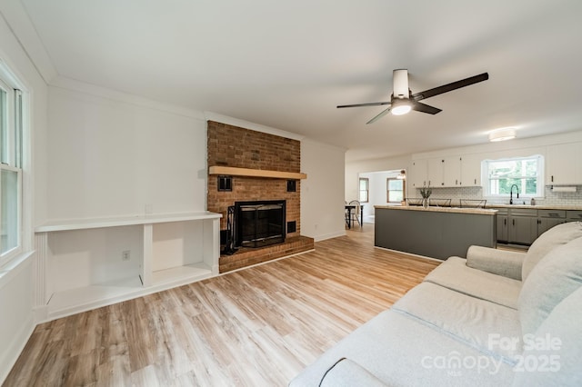 2109 Rock Springs Cir, Denver, NC 28037 - living area featuring ceiling fan, light wood-style floors, a fireplace, baseboards, and crown molding