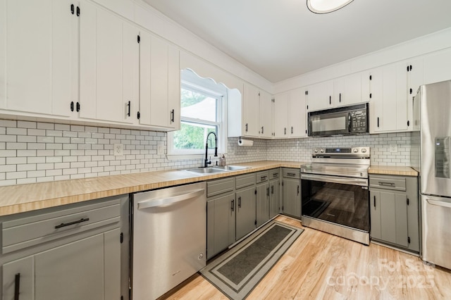 2109 Rock Springs Cir, Denver, NC 28037 - kitchen featuring appliances with stainless steel finishes, gray cabinetry, a sink, light wood-style flooring, and tasteful backsplash