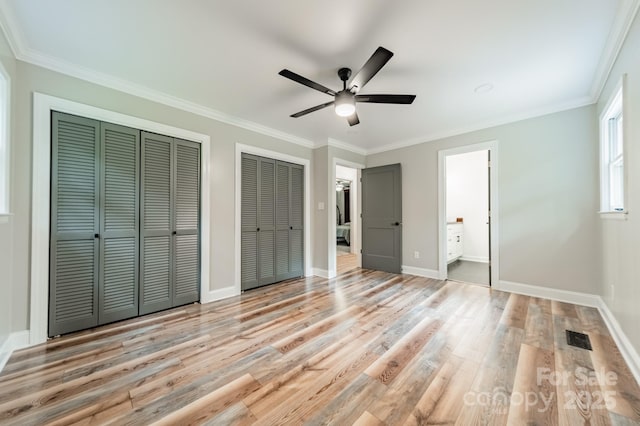 2109 Rock Springs Cir, Denver, NC 28037 - unfurnished bedroom with multiple closets, light wood-type flooring, baseboards, crown molding, and ensuite bathroom