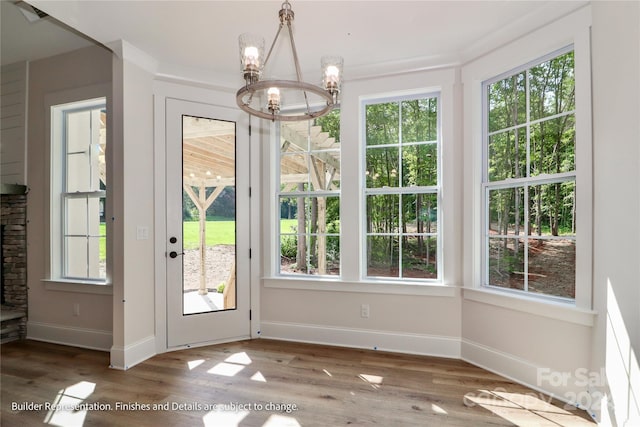 doorway with hardwood / wood-style flooring and an inviting chandelier