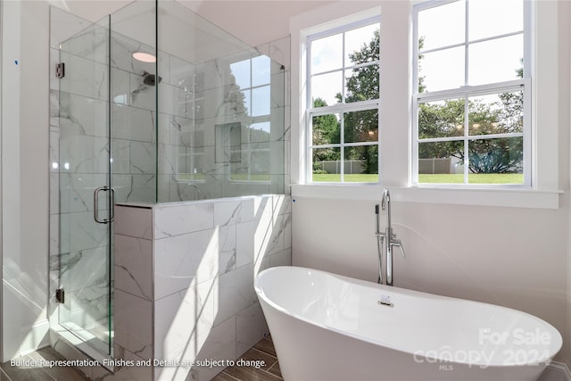 bathroom featuring wood-type flooring and shower with separate bathtub