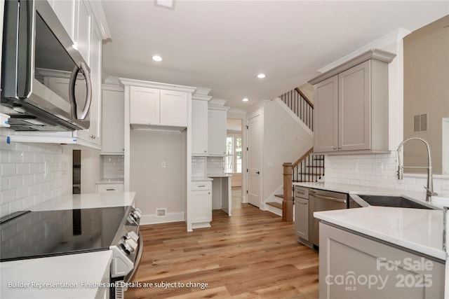 kitchen with stainless steel appliances, a sink, visible vents, recessed lighting, and decorative backsplash