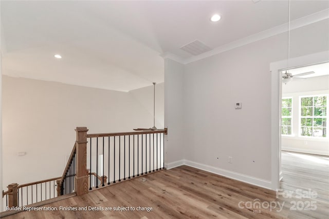 interior space featuring recessed lighting, wood finished floors, baseboards, and an upstairs landing