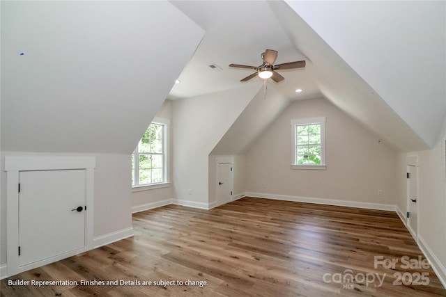 additional living space featuring vaulted ceiling, wood finished floors, ceiling fan, baseboards, and visible vents
