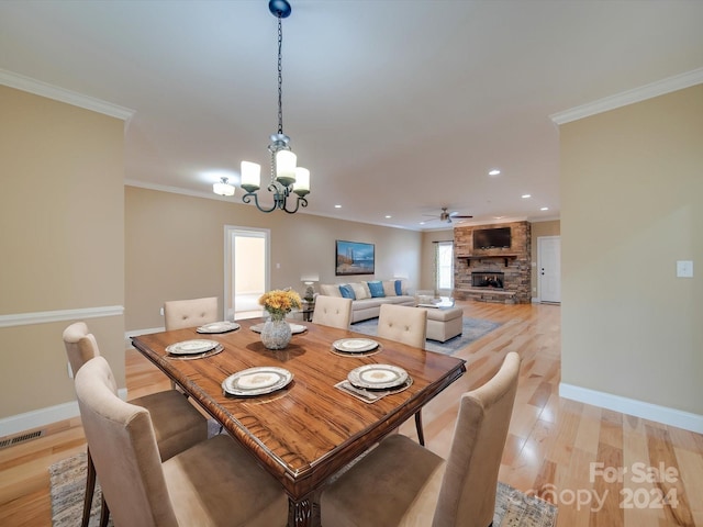 dining space with ornamental molding, light hardwood / wood-style floors, and a healthy amount of sunlight