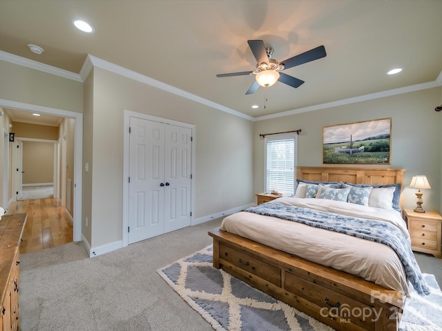 carpeted bedroom with a closet, ceiling fan, and crown molding