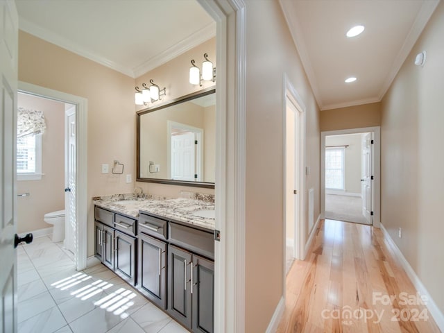 bathroom featuring wood-type flooring, plenty of natural light, and ornamental molding