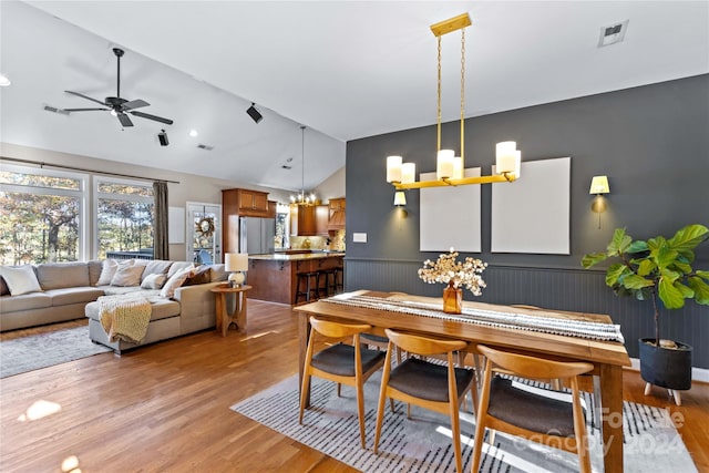 169 Rimmer Farm Rd, Troutman, NC 28166 - dining space featuring a chandelier, vaulted ceiling, light wood-style floors, wainscoting, and a ceiling fan