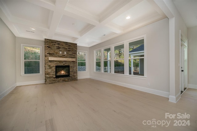 unfurnished living room featuring beamed ceiling, light wood-type flooring, a fireplace, and coffered ceiling