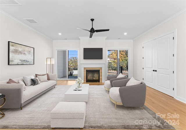 living room with plenty of natural light, light hardwood / wood-style floors, and crown molding