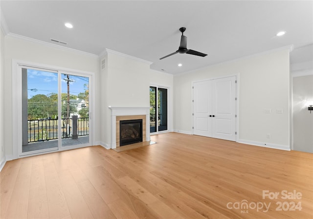 unfurnished living room featuring ceiling fan, ornamental molding, a healthy amount of sunlight, and light wood-type flooring