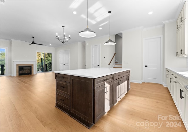 kitchen with white cabinets, pendant lighting, and light hardwood / wood-style floors