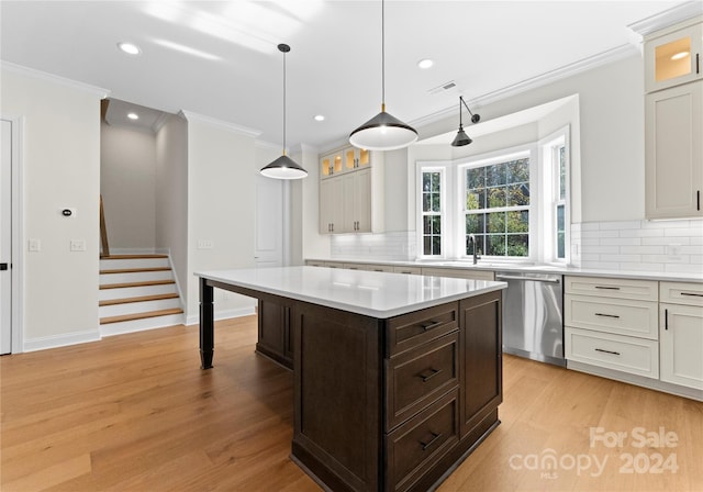 kitchen featuring dishwasher, a kitchen island, light wood-type flooring, and tasteful backsplash