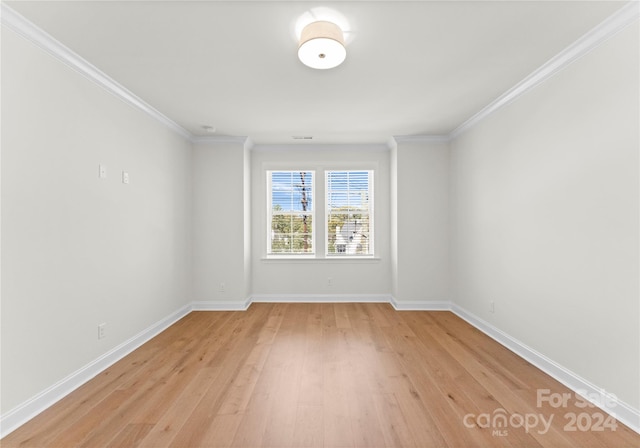 empty room with ornamental molding and light hardwood / wood-style flooring