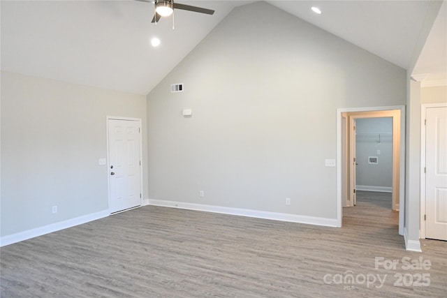 spare room featuring light wood-type flooring, ceiling fan, and high vaulted ceiling