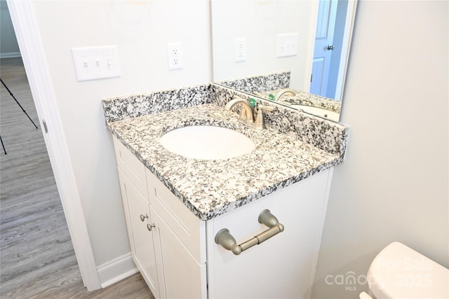 bathroom featuring hardwood / wood-style flooring, toilet, and vanity