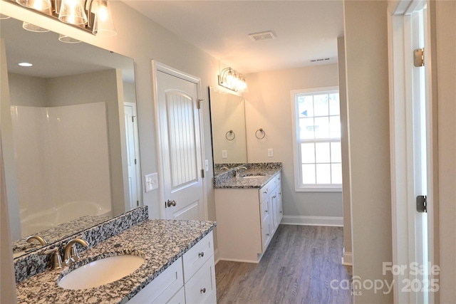 bathroom with vanity, hardwood / wood-style flooring, and a shower