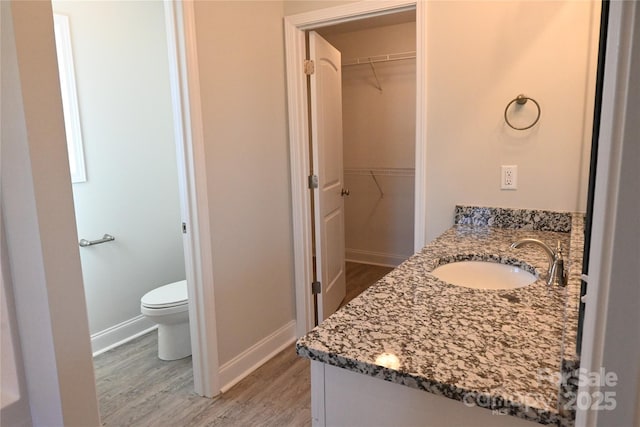 bathroom with hardwood / wood-style floors, toilet, and vanity