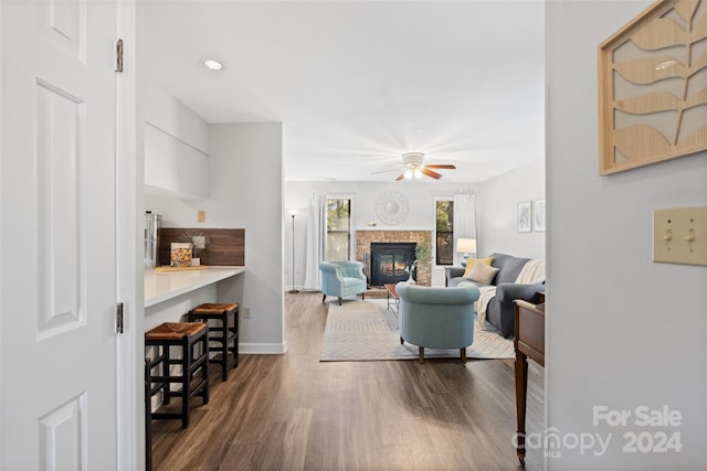 living room featuring ceiling fan and dark hardwood / wood-style flooring