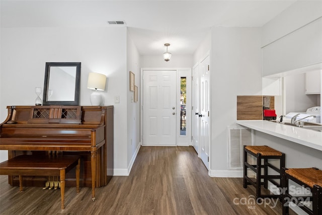 foyer entrance featuring sink and dark hardwood / wood-style floors