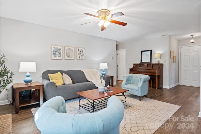 living room featuring ceiling fan and dark hardwood / wood-style flooring